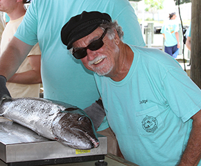 Dr. Bob Shipp at the fishing rodeo with a fish on the scale.