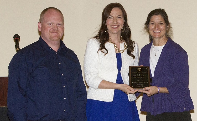 Toni Ann Torrans, director of Penelope House, right, accepts the Outstanding Research Partner Award for 2013-2014. Dr. Phil Smith, left, assistant professor of psychology, nominated Torrans for the award. Also pictured is Dr. Julie Estis, president of the USA Faculty Senate.