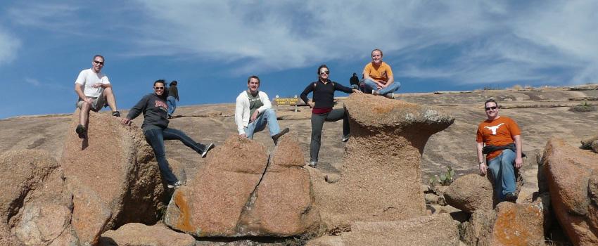 Six students standing on rocks