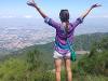 Study Abroad with arms in the air looking out over the land