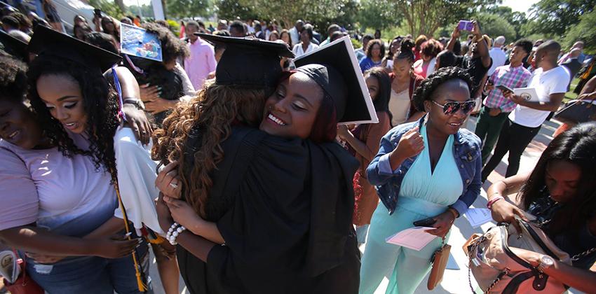 Two students hugging during graduation