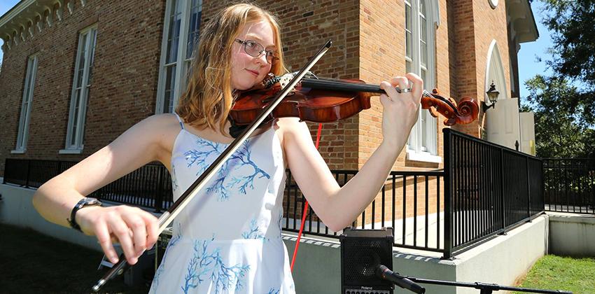 Student playing Violin in front of Honors