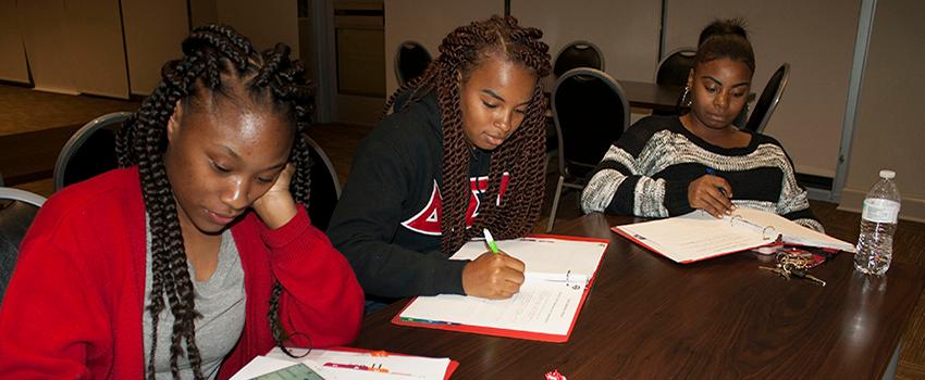 Three students writing
