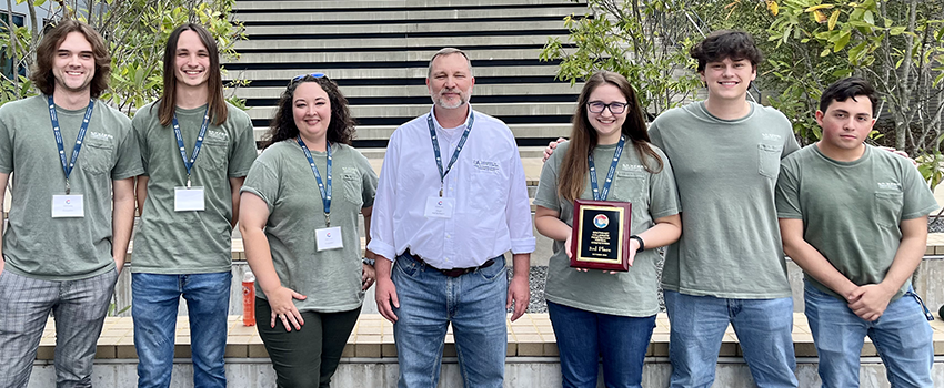 Students with Dr. Andel holding plaque.