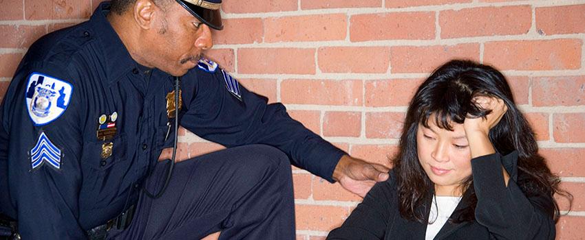 Police Officer helping a woman sitting on the floor