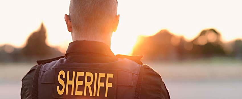 The back of a sheriff looking out at the sun