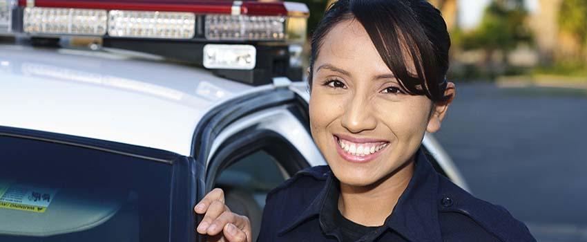 Smiling Female Police Officer in front of her car