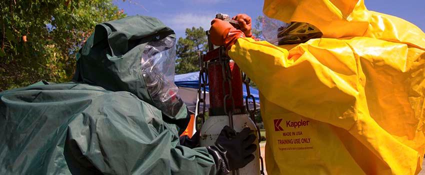 Two men in hazmat suits in working with equiment