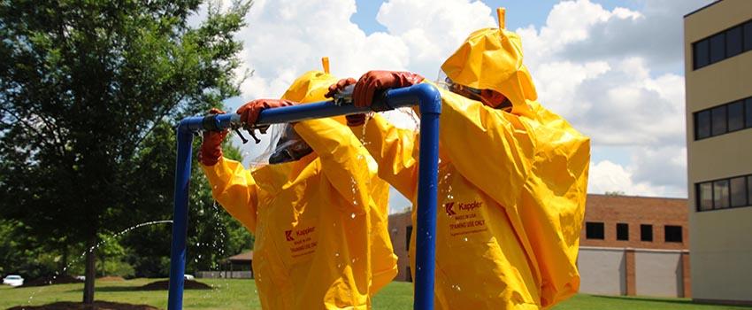 Two men in hazmat suits on metal bar