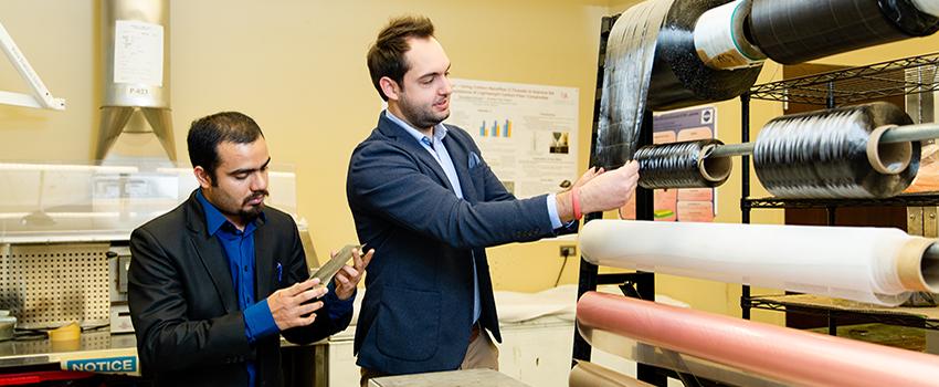 Professor and student working in lab with rolling material