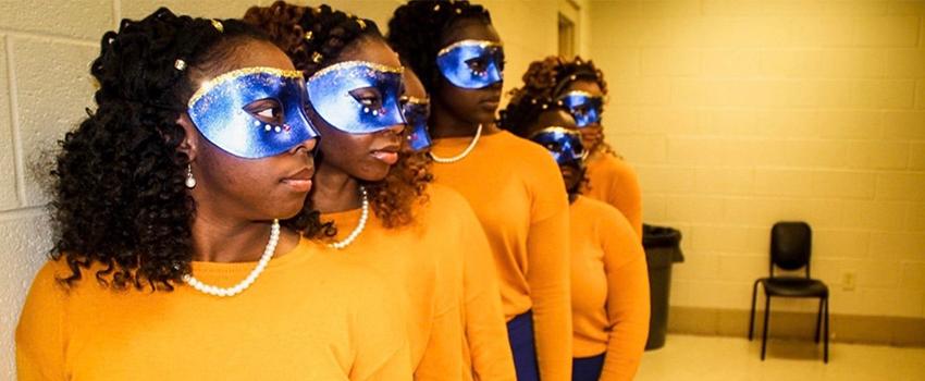 NPHC Female students with purple masks and yellow sweaters on