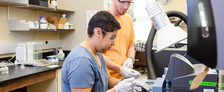 Two students working on a slide in the lab.