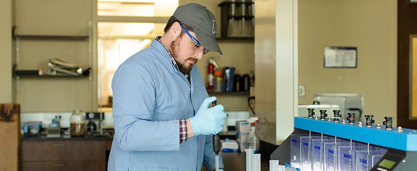 Civil Engineering student using dropper in lab.