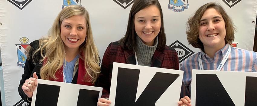 Three female students holding HKN Sign