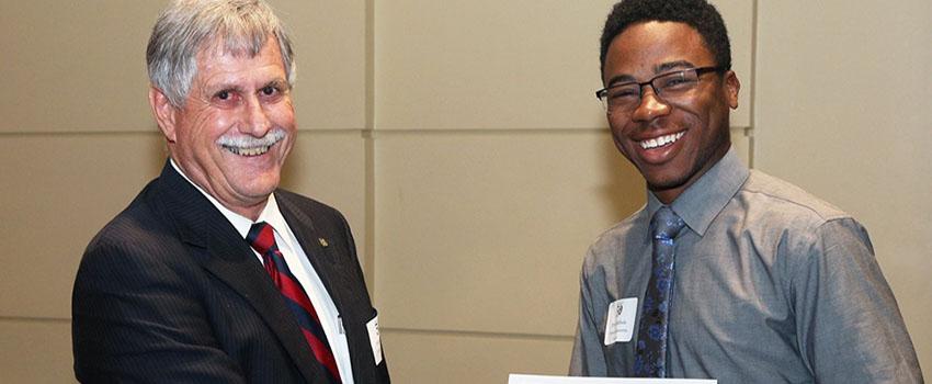 Dr. Steadman shaking hands with an engineering scholarship recipient.
