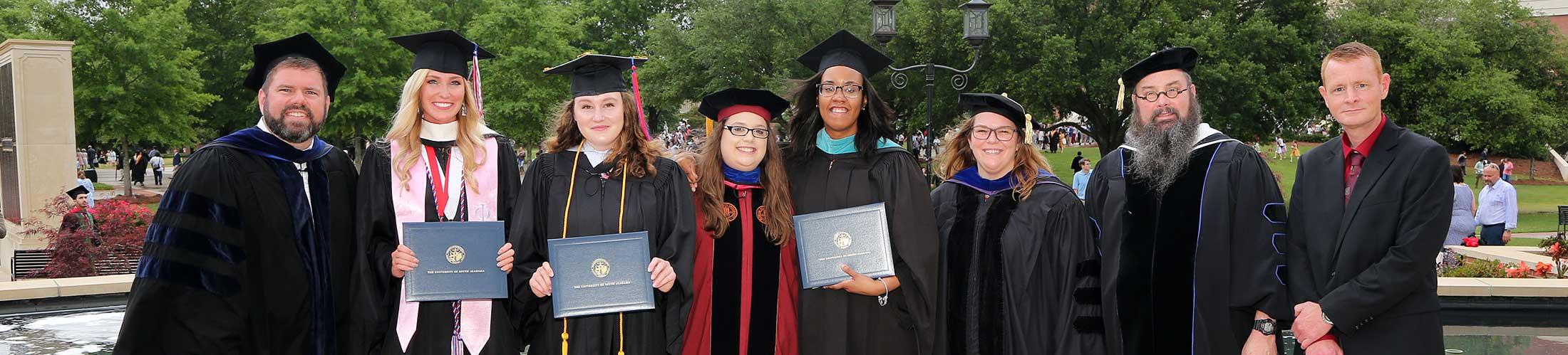 Group of graduates with faculty at graduation