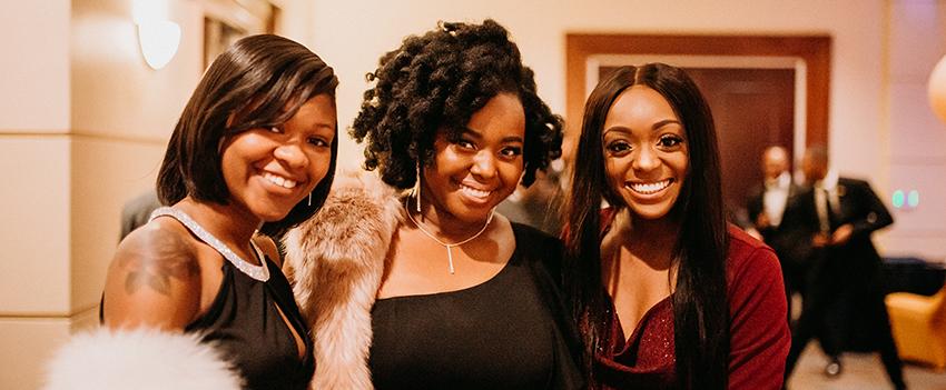 Three friends pose for a picture at the banquet