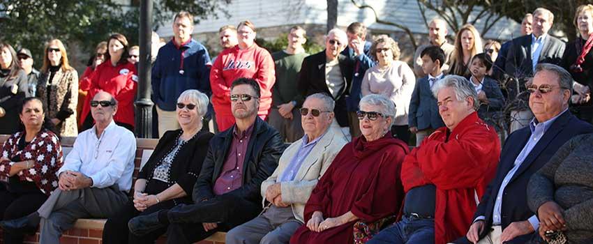 Crowd at Alumni Center watching speech in front of new center.