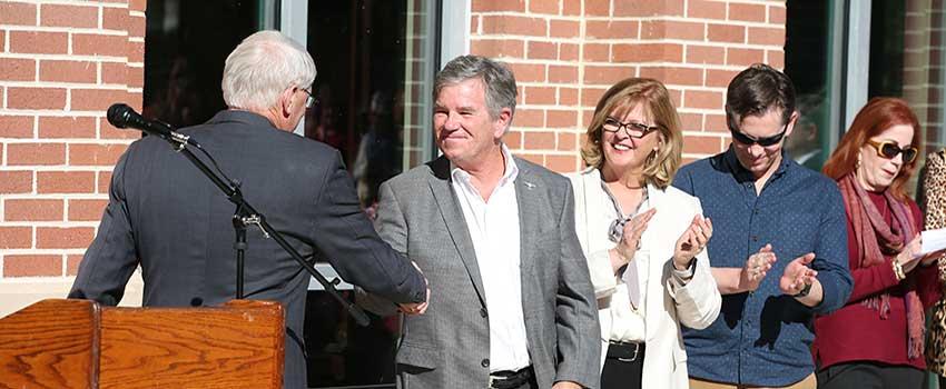 Dr. Waldrop shaking hands of Mr. MacQueen at ceremoney for new Alumni Center