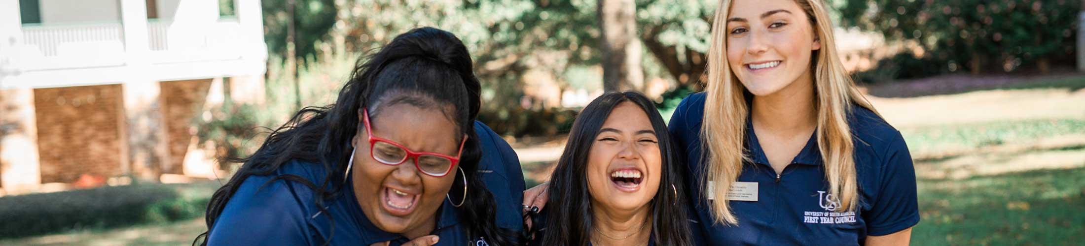 Three members of First Year Council (FYC) laughing outside.