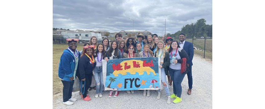 FYC holding banner at homecoming game