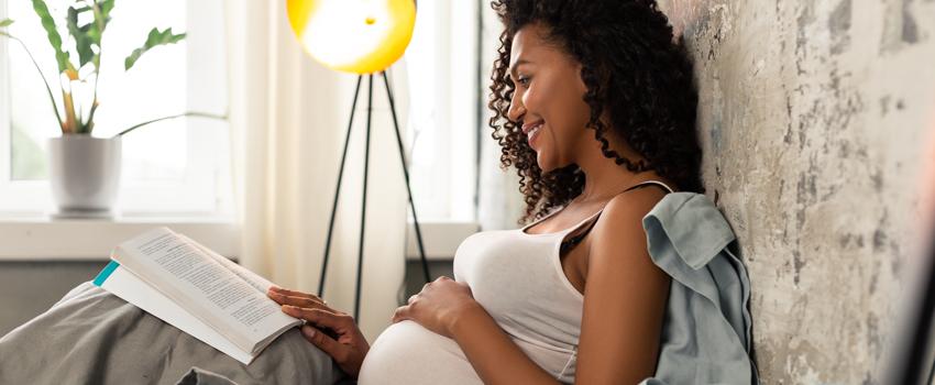 A pregnant woman looking at book