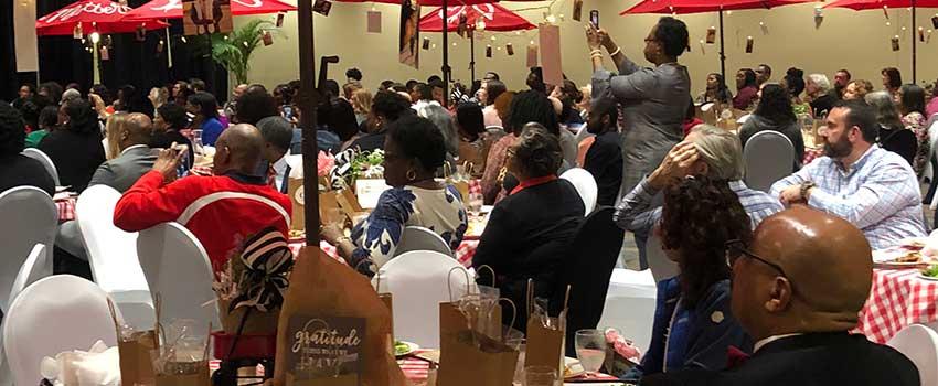 People gathered for luncheon sitting at tables.