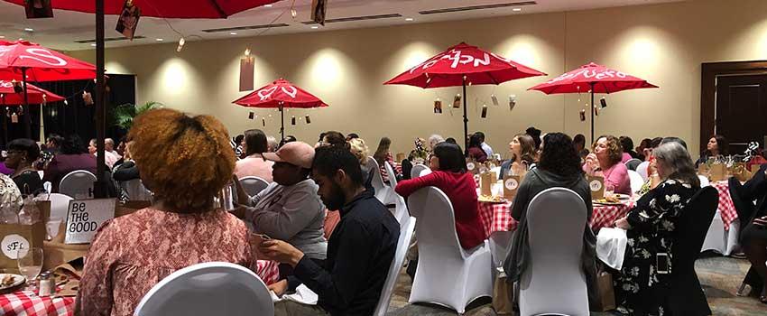 People gathered for luncheon sitting at tables.