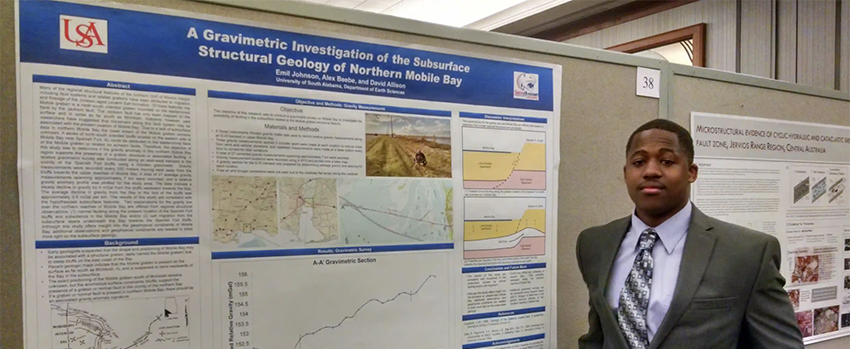 Male student standing in front of his Geology project.