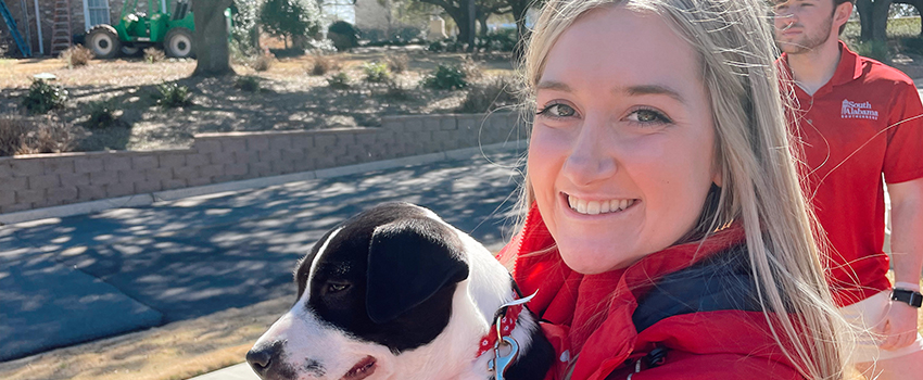 Sarah Hemelt holding a dog during the saving a stray fostering program.