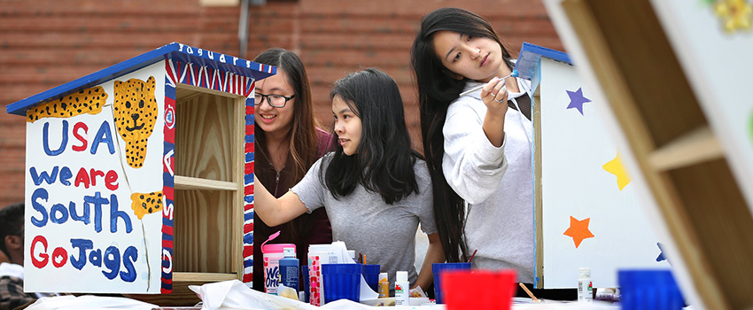 Students painting birdhouses.