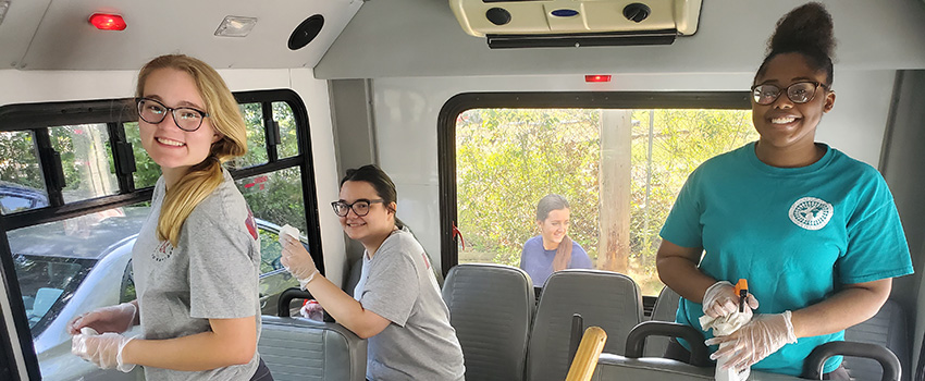 Volunteers cleaning a bus.