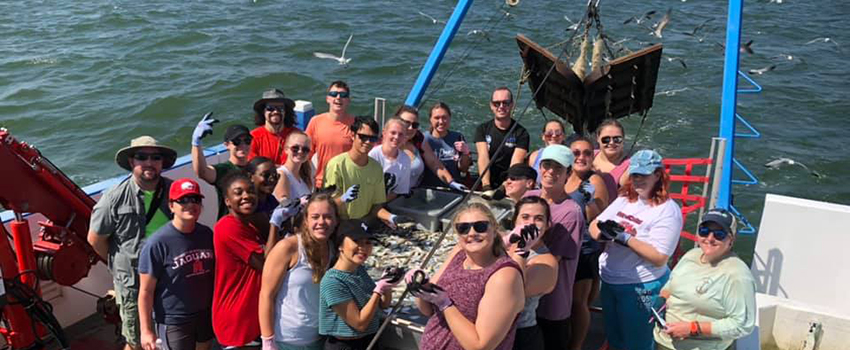 Marine Sciences class on boat working with fish.