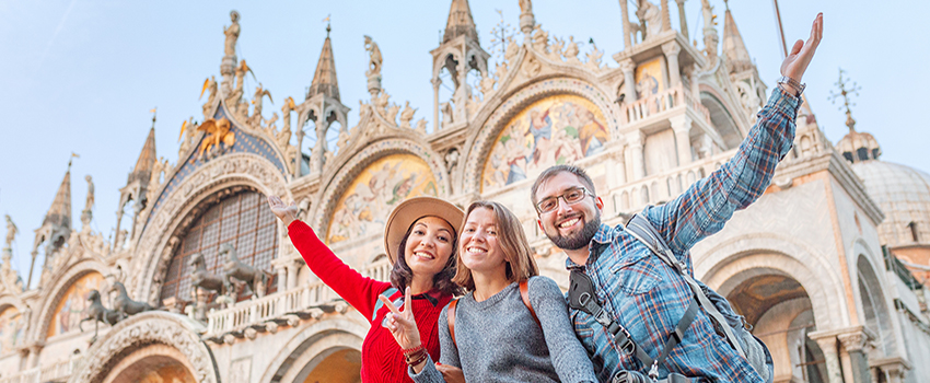 Three students smiling in front of Italian castle