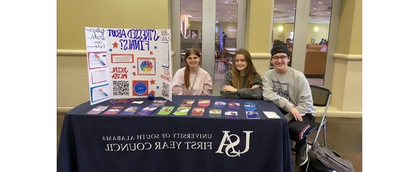 Peer counselors in student center with table set up for information for students.