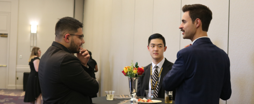 Mortar Board members at an event speaking around a table.