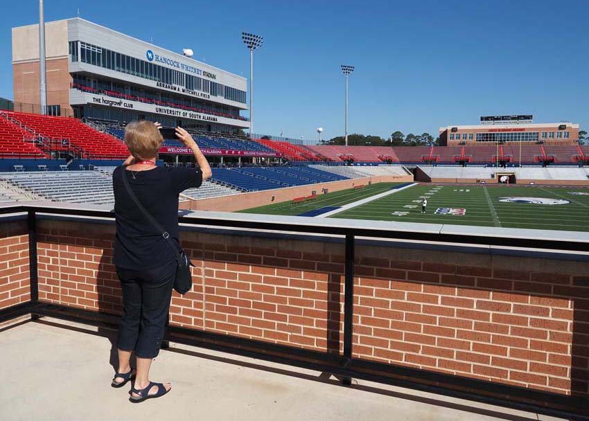 Person overlooking football field taking a picture.