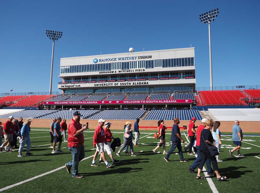 Group walking on football field.