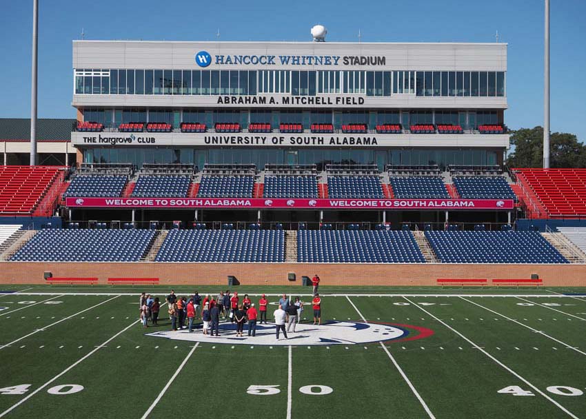 Group in front of stands on football field wide shot.