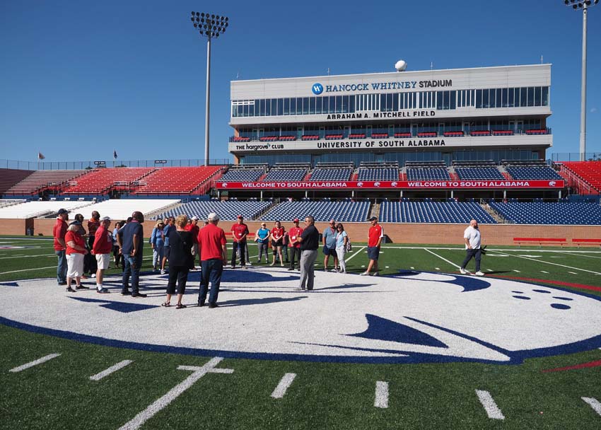 Group in front of stands on football field.