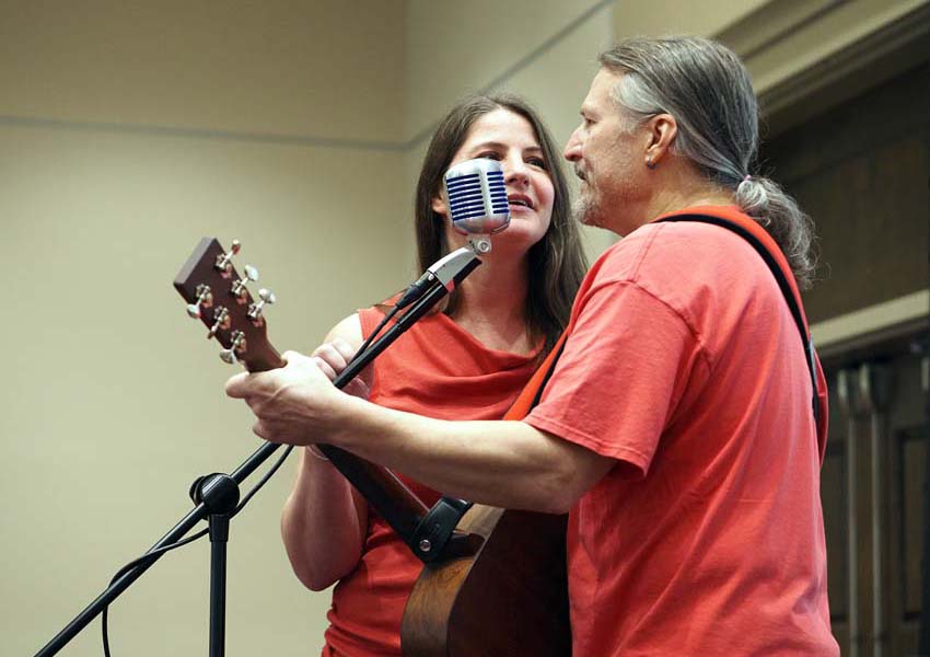 Two people singing and playing the guitar.