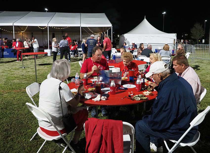 Attendees of the All Class Party 2022 sitting at tables eating.