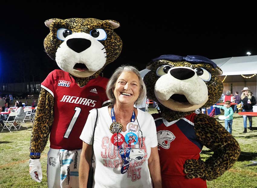 Ms. Pawla and South Paw poses for a picture with an attendee of the 2022 All Class Party