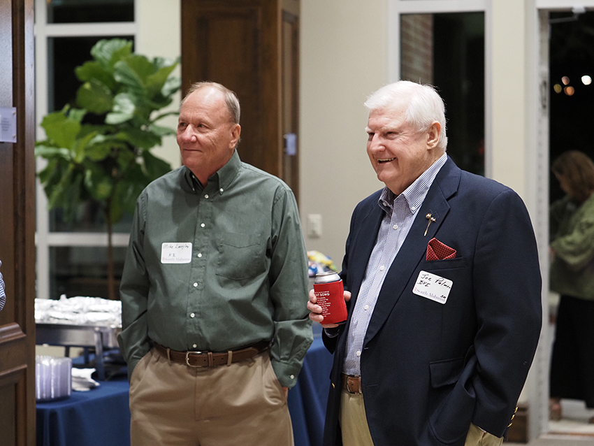 Two men at greek reunion talking.