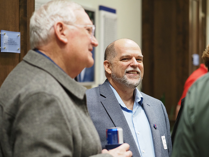 Two men at greek reunion talking.