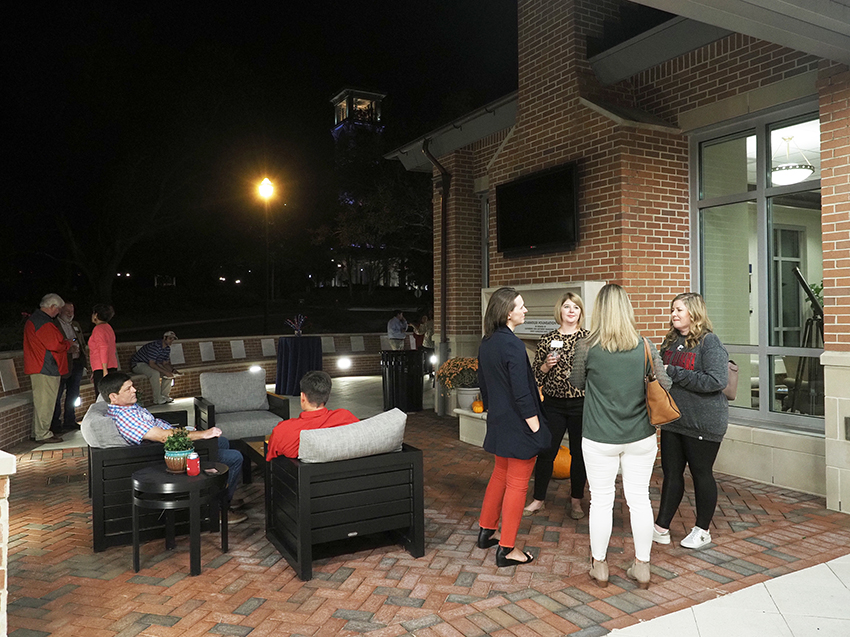 People talking at the outdoor patio at the MacQueen Center.