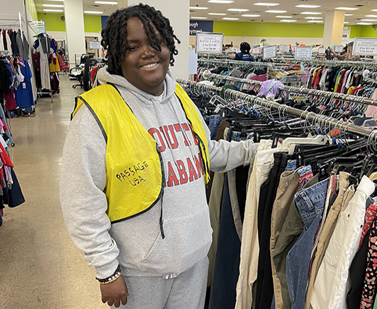 Roderick in front of clothes at the Goodwill.