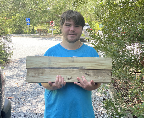 Noah at Pascagoula holding wood.