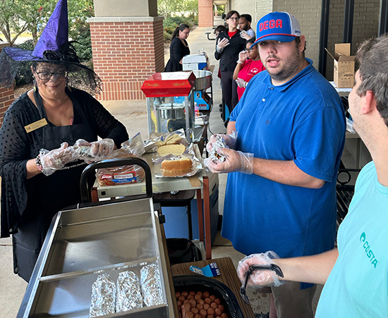 Passage USA Student serving hotdogs to customers.