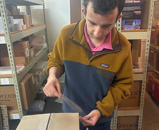 Passage USA student taping box closed.